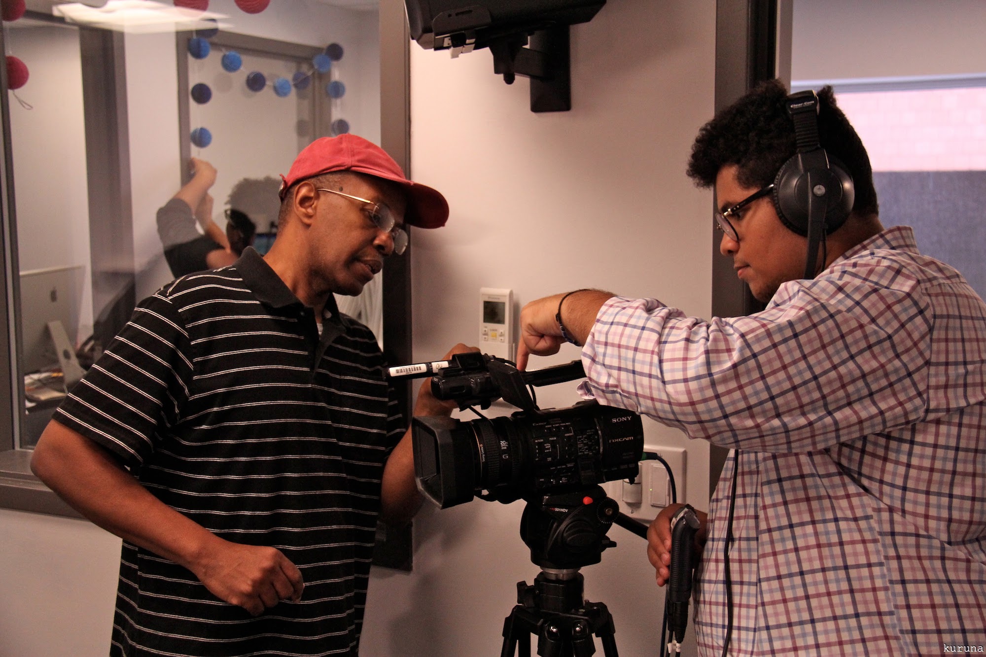 Intern being instructed on video camera recording